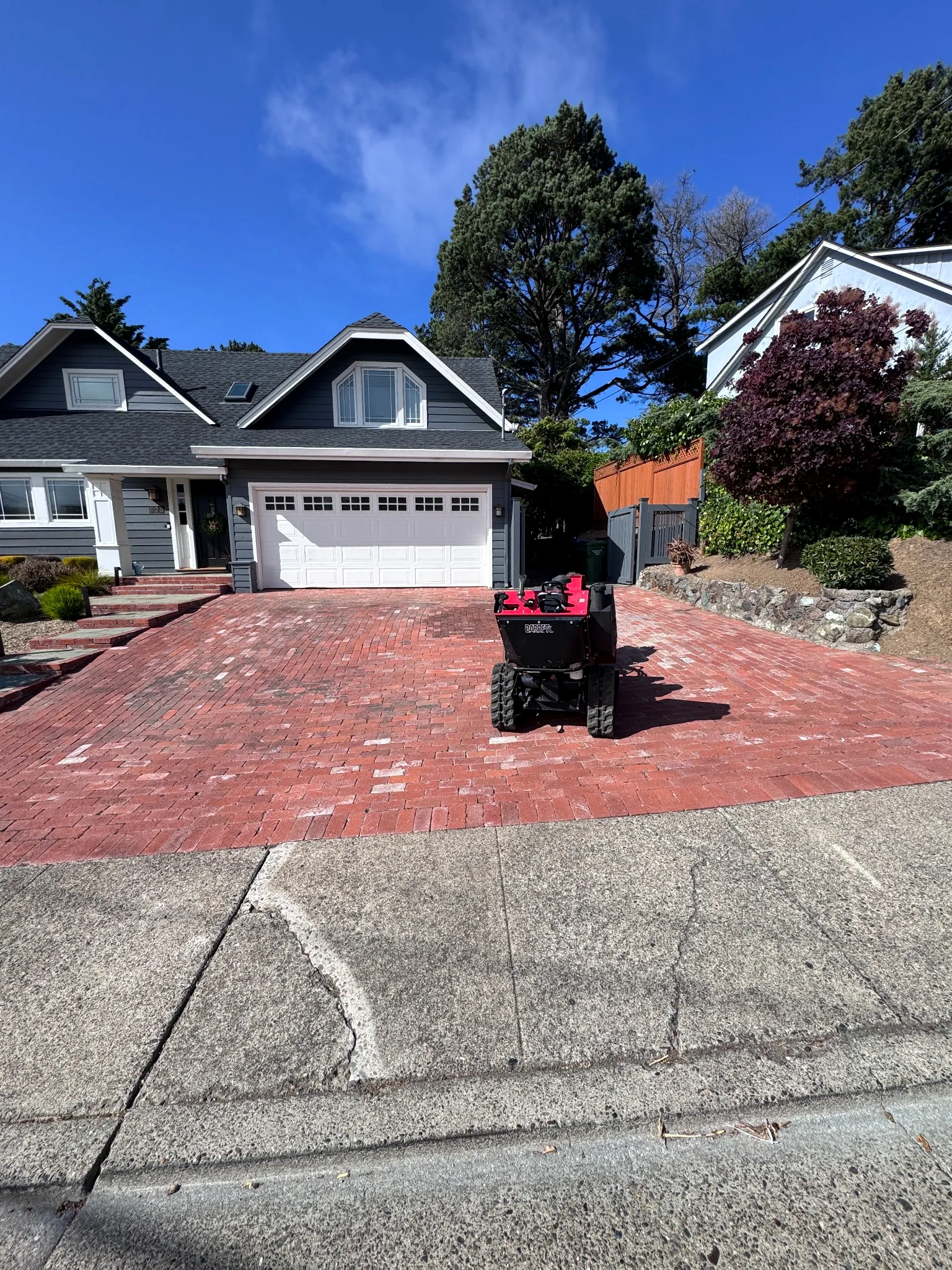 Professional stump grinder positioned in front of a North Bay home
